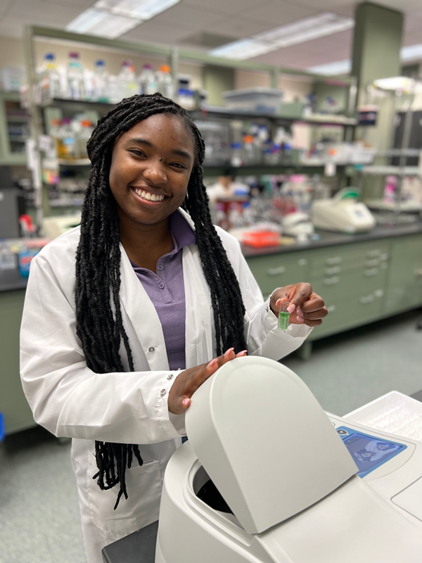 Photo of undergraduate research student doing work in their lab.