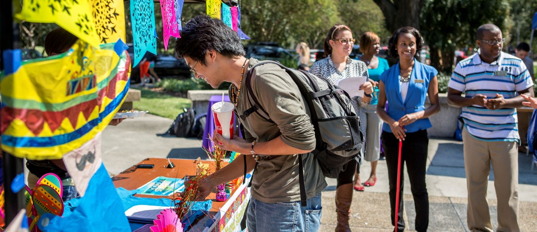 people smile around a booth at an outdoor fair